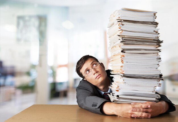 Homme avec une pile de dossiers avec des documents en arrière-plan