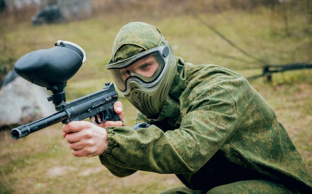 Homme avec pistolet jouant au paintball. En plein air