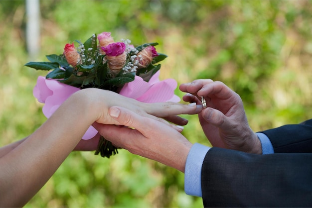 Un homme place une bague au doigt d'une mariée pour faire sonner son alliance.