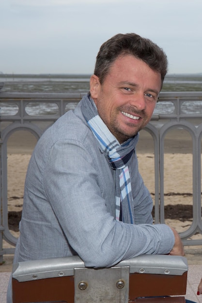 Homme à la plage avec foulard en regardant la caméra