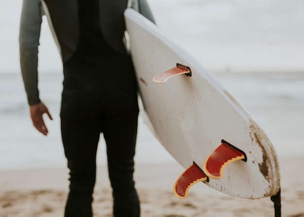 Photo homme à la plage avec sa planche de surf