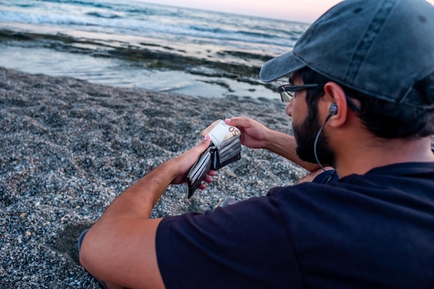 Homme à la plage avec son argent