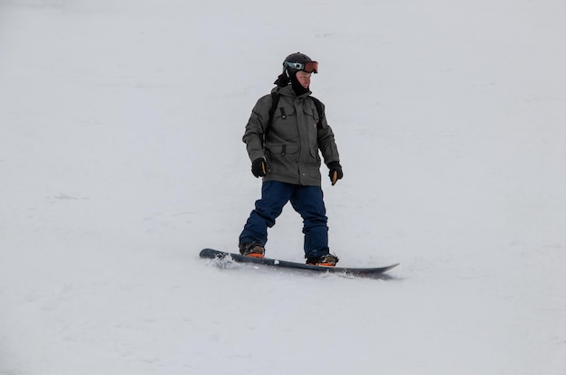 Photo un homme sur une planche à neige descend le flanc de la montagne