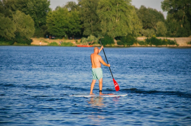 Homme sur une planche de SUP dans la rivière