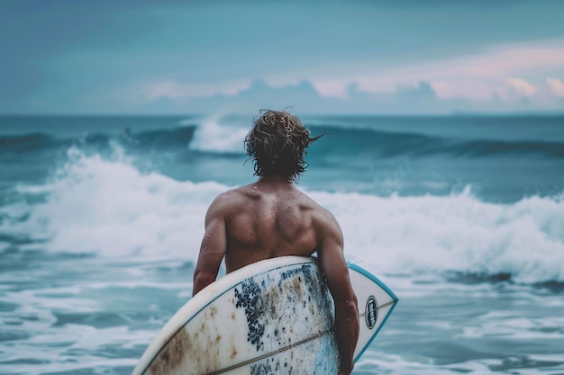 Un homme avec une planche de surf sur la plage.