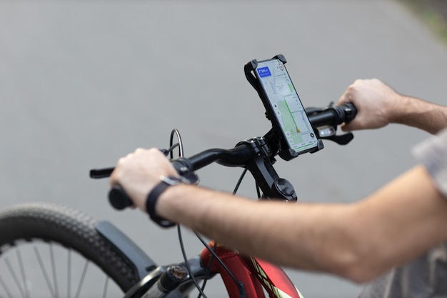 Homme planifiant un itinéraire à l'aide de l'application de navigation gps sur son téléphone portable sur son vélo