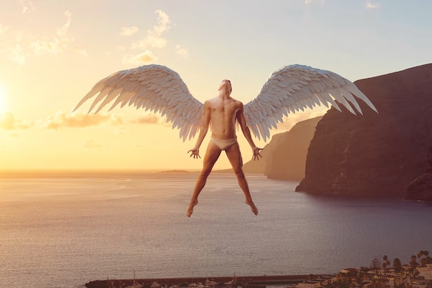 Photo homme plein coup avec des ailes au bord de la mer