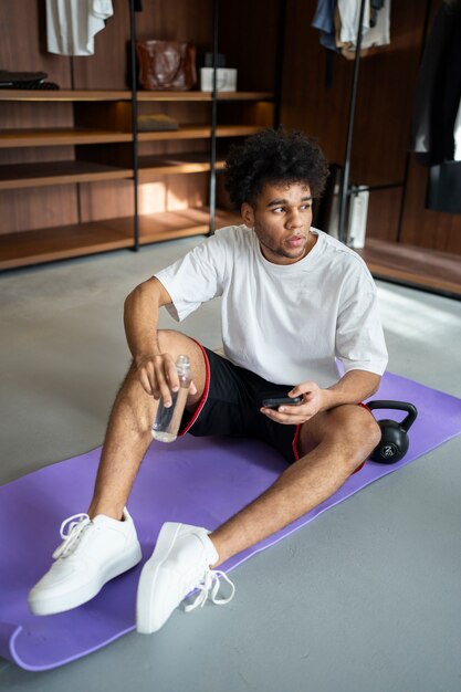 Homme plein coup assis sur un tapis de yoga