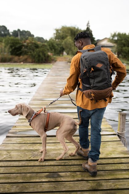 Homme plein coup marchant avec un chien