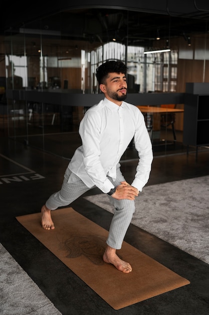 Photo homme plein coup qui s'étend au travail