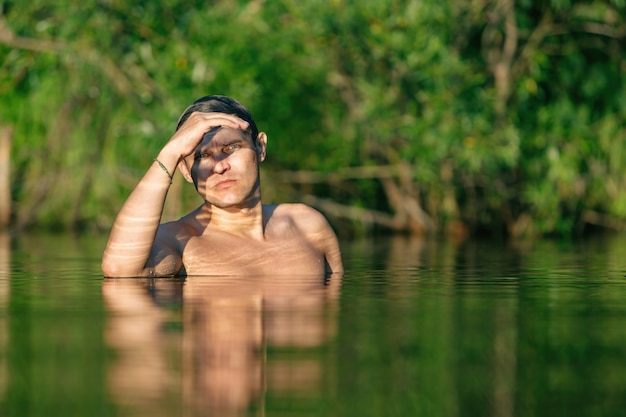 L'homme a plongé dans l'eau. Le gars se lève contre sa poitrine dans l'eau.