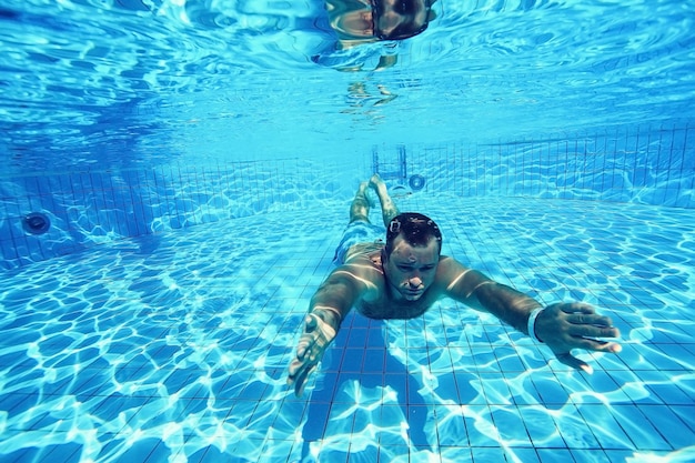 homme plonge dans la piscine photo sous-marine