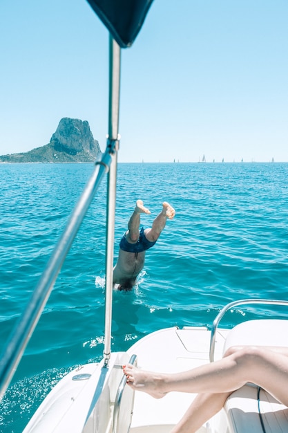 Homme plongeant dans l'eau du bateau