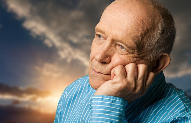 L'homme plus âgé est triste sur le fond de ciel