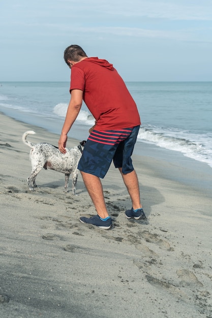 Homme plus âgé s'amuser avec son chien à la plage