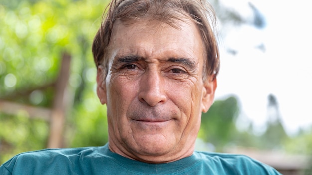 Homme plus âgé souriant sur la nature.