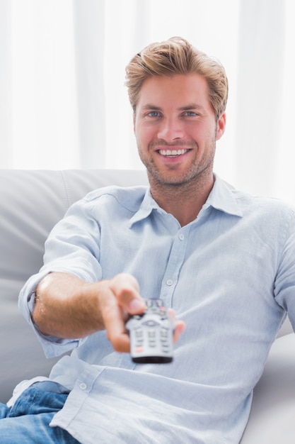 Homme pointant la télécommande à la caméra