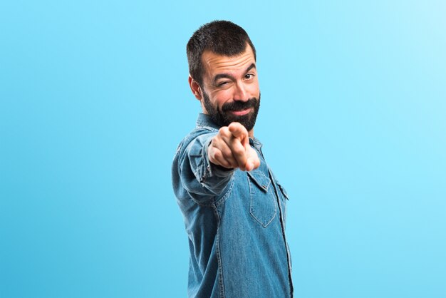 Homme pointant vers l&#39;avant sur fond coloré