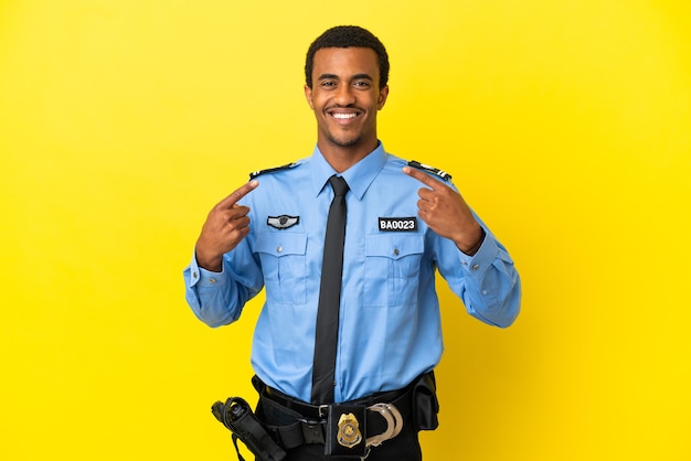 L'homme de la police afro-américaine sur fond jaune isolé donnant un coup de pouce geste