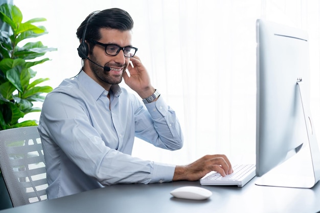 Un homme portant un casque est assis devant un ordinateur.