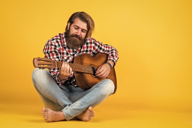 Homme portant une chemise à carreaux et tenant un instrument de musique à cordes jouant de la guitare musicien caucasien professionnel guitariste hipster homme jouant de la guitare acoustique style de musique country espace de copie