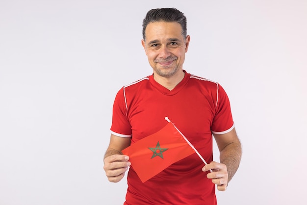 Homme portant une chemise marocaine rouge tenant un drapeau marocain Coupe du monde de sport et concept de fan