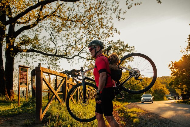 Homme portant un chien dans un sac à dos pour animaux de compagnie lors d'un voyage à vélo