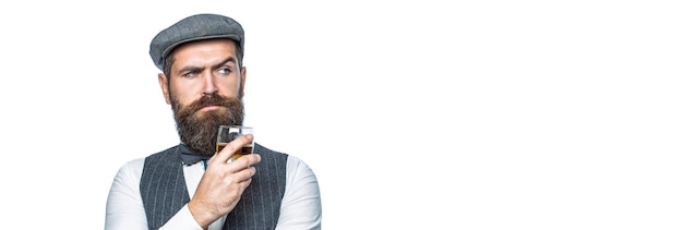 Homme portant un costume et buvant du whisky brandy cognac Bearded in tient un verre de whisky Bel homme bien habillé en veste avec un verre de boisson