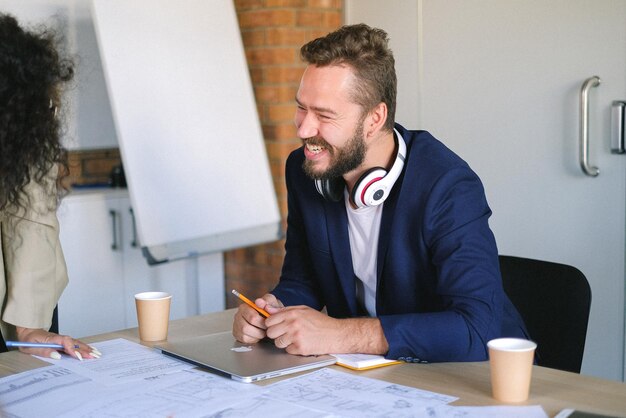 un homme portant des écouteurs est assis à un bureau avec un papier dessus