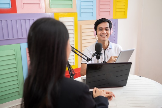 Un homme portant des écouteurs lors d'un podcast avec une femme