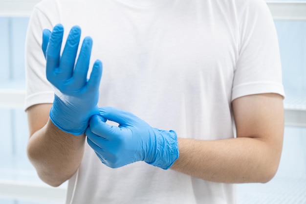 Un homme portant des gants en nitrile bleu