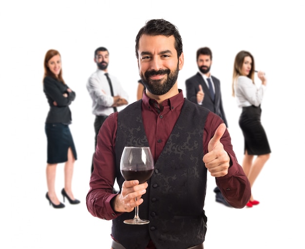 Homme portant un gilet tenant un verre à vin