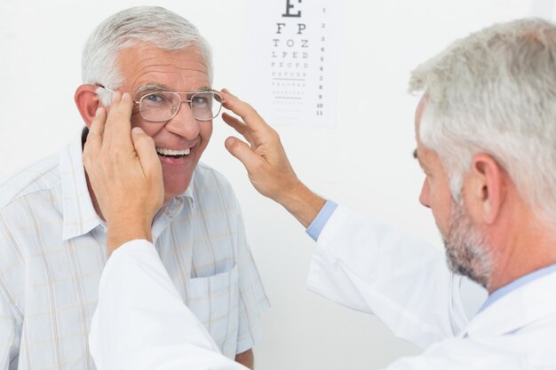 Photo homme portant des lunettes après avoir subi un examen de la vision chez le médecin