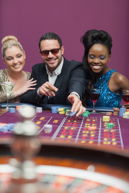 Homme portant des lunettes de soleil avec des femmes à la roulette