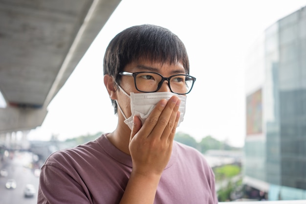 Un homme portant un masque facial protège le filtre contre la pollution de l'air (PM2.5)