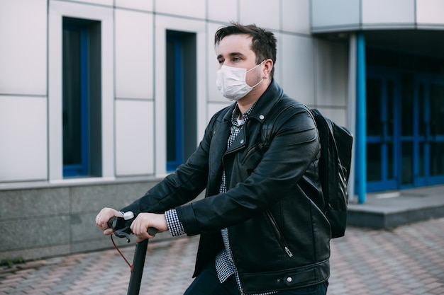 homme portant un masque hygiénique à l'aide de scooter