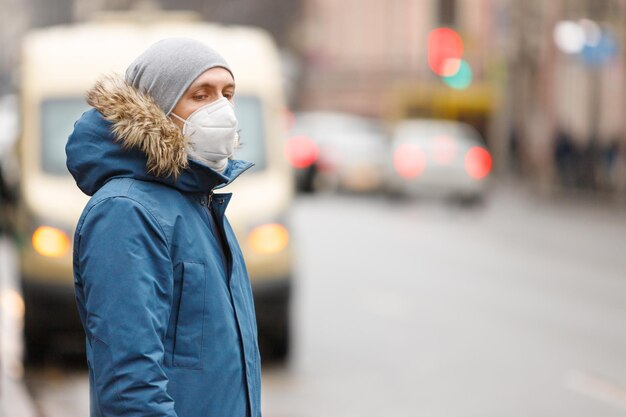 Un homme portant un masque et un manteau de fourrure se tient dans la rue pendant l'hiver