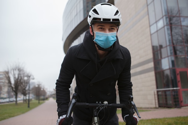 Homme Portant Un Masque Médical Et Un Casque De Protection En Vélo