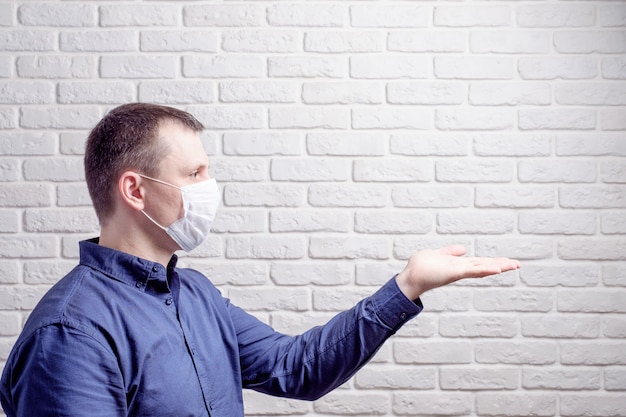 Homme portant un masque médical contre le mur