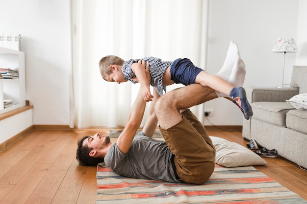 Homme portant son fils sur la jambe pendant l&#39;exercice