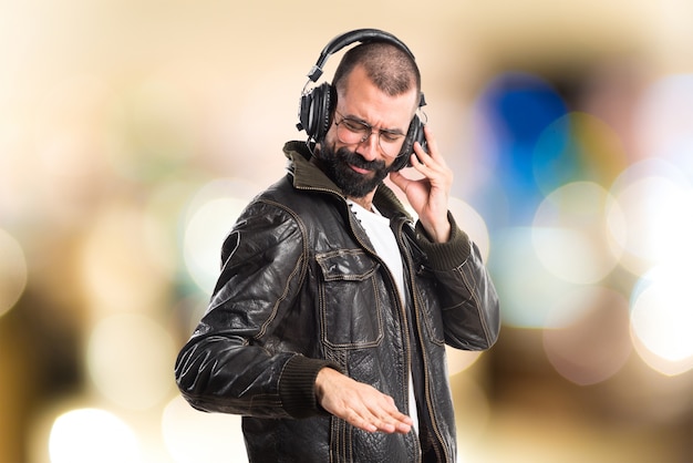 Homme portant une veste en cuir écoutant de la musique en arrière-plan non focalisé