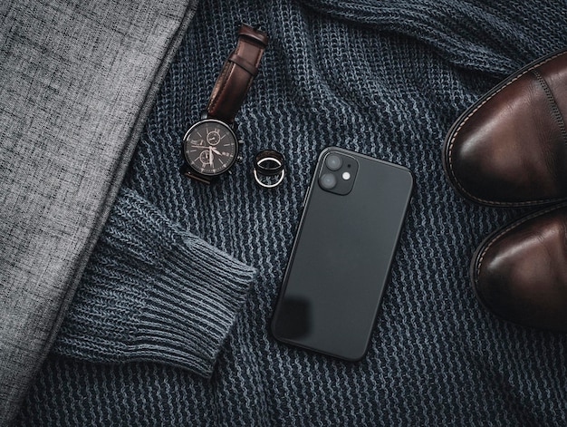 Photo un homme porte un chandail et une montre par terre à côté d'une montre.