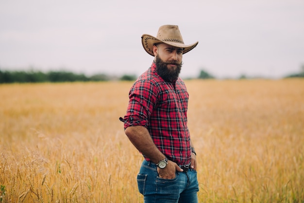 Homme porté avec un chapeau dans un champ