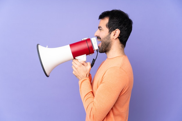 Homme posant en criant pensait un mégaphone