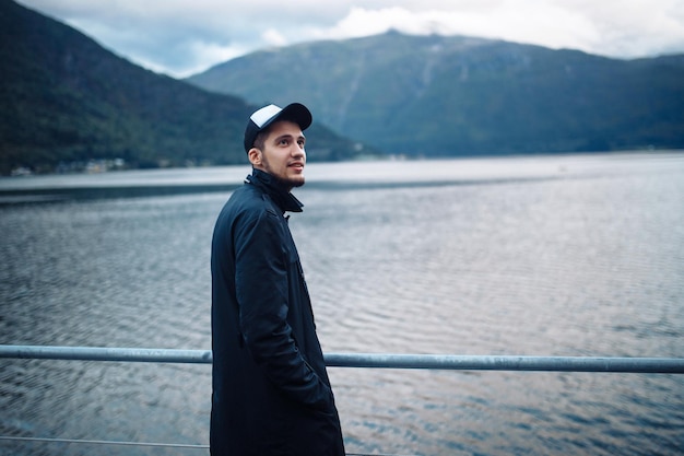 Homme posant sur fond de montagnes en Norvège Homme randonnée touristique au magnifique lac de montagne