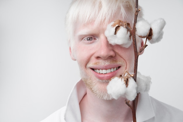 Photo homme posant avec une plante de coton