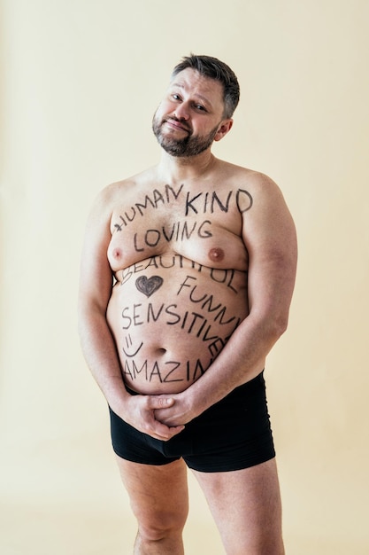 Homme posant pour un ensemble de beauté positive pour le corps édition masculine. Mec torse nu portant des sous-vêtements de boxeurs en studio