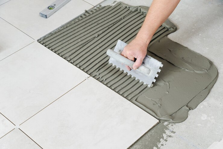 L'homme pose des carreaux de céramique.