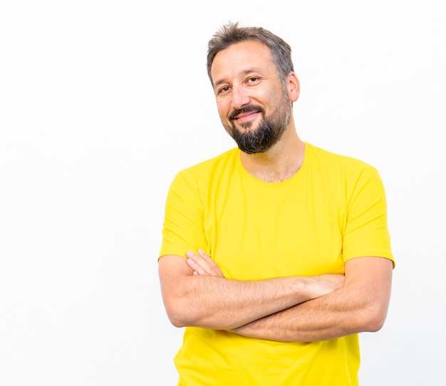 Un homme positif avec un portrait de chemise jaune contre le mur