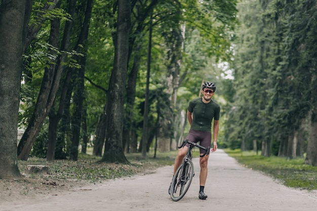 Homme positif en vêtements de sport prenant une pause après le cyclisme